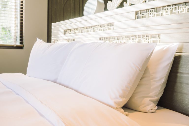 Beautiful white pillow on bed decoration in bedroom interior - Vintage light Filter